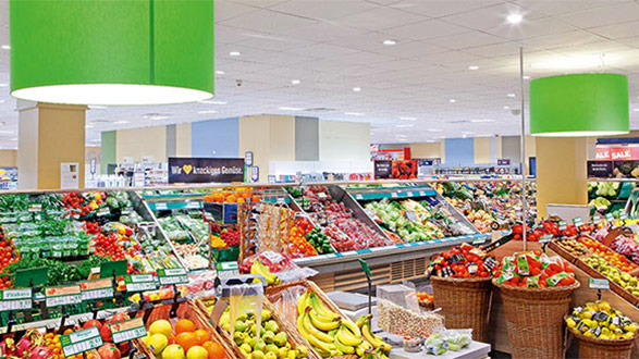 Luminaria Philips con reflectores PerfectAccent iluminando agradablemente un supermercado Edeka